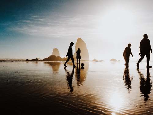haystack rock silhouette of people walking body of water united states